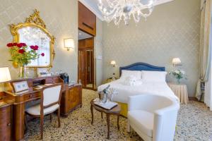 Schlafzimmer mit einem Bett, einem Schreibtisch und einem Spiegel in der Unterkunft Hotel Colombina in Venedig