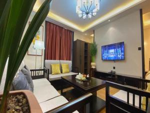 sala de estar con sofá y TV en GreenTree Inn Express Datong High-Speed Railway Station Wanda Plaza Fangte en Shaling