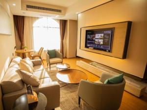 Mangshi的住宿－GreenTree Inn Jumang Plaza，带沙发和平面电视的客厅