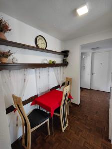 a dining room with a table and chairs and a clock at 2 bedroom Apartment at Bahnhofcity in Feldkirch