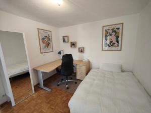 a bedroom with a desk and a bed and a desk and chair at 2 bedroom Apartment at Bahnhofcity in Feldkirch