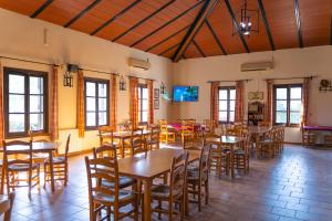 a dining room with wooden tables and chairs at Kampaoh El Rocío in El Rocío