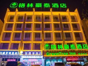 budynek z neonowymi znakami przed nim w obiekcie GreenTree Inn Xinjiang Kashgar Food Street w mieście Kaszgar