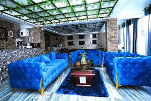 a living room with blue couches and a brick wall at Hotel The Relyn Suite Shillong in Shillong
