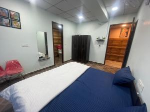 um quarto com uma cama azul e branca e um espelho em Shiv shakti guest house em Bhiwāni
