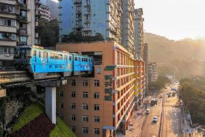 un tren azul sobre un puente sobre una ciudad en Xiangsu Boang Hotel en Chongqing
