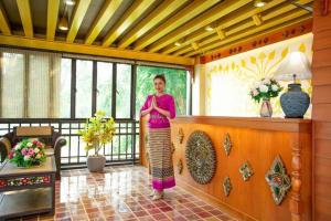 a woman standing on a balcony in a room at KOKHABURI HOTEL in Ban Chomphu