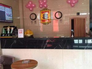 a restaurant with clocks on the wall and a table at Super 8 Hotel Dingzhou Chongwen Street in Baoding