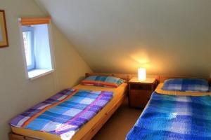 two beds in a small room with a window at Ferienwohnung Birnengarten am Pfarrgarten Starkow in Velgast