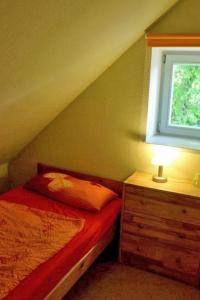 a small bedroom with a bed and a window at Ferienwohnung Birnengarten am Pfarrgarten Starkow in Velgast