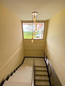 Una escalera en una habitación con ventana en HOTEL KANGURU TIMIKA en Timika