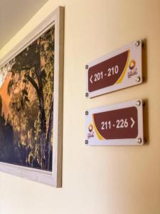 deux signaux sur un mur à côté d'une image dans l'établissement HOTEL KANGURU TIMIKA, à Timika