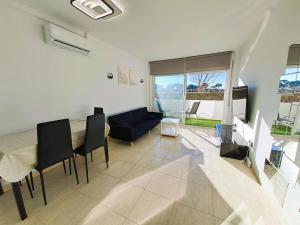 sala de estar con mesa, sillas y sofá en Apartamento 1a línea de mar, en Empuriabrava