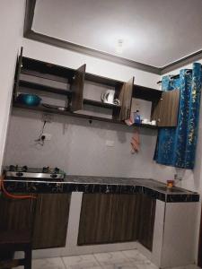 cocina con encimera y armarios de madera en Rihan studio apartment, en Mombasa