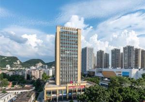 ein hohes Gebäude mitten in einer Stadt in der Unterkunft Echarm Hotel Liuzhou Liunan Wanda Plaza Liuyong Road in Liuzhou