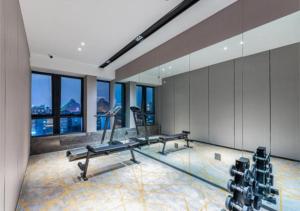 einen Fitnessraum mit zwei Bänken und Fenstern in einem Gebäude in der Unterkunft Echarm Hotel Liuzhou Liunan Wanda Plaza Liuyong Road in Liuzhou