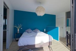 a blue bedroom with a bed and a blue wall at L'Oasis - villa avec piscine chauffée classée 5* in Périgny +33 photos
