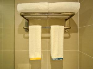 two towels hanging on a towel rack in a bathroom at City Comfort Inn Wuhan South Lake Zhongnan University of Economics and Law Fashion City in Liufangling