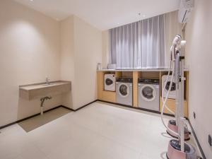 a laundry room with two washing machines and a sink at City Comfort Inn Wuzhou Xijiang Thrid Bridge in Cangwu