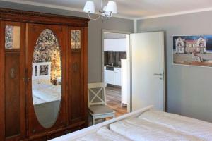 a bedroom with a wooden dresser with a mirror at Ferienwohnung Irisgarten am Pfarrgarten Starkow in Velgast