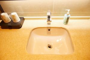 a bathroom sink with two toothbrushes on a counter at City Comfort Inn Changchun 3rd Bethune Hospital of Jilin University Zhongdong in Changchun