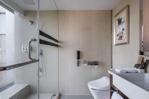a bathroom with a shower with a toilet and a sink at Novotel Nanjing Central in Nanjing