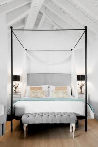 a bedroom with a large bed with a canopy at Hotel Mercader de Sedas in Granada