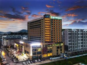 un edificio alto con luces encendidas en una ciudad en City Comfort Inn Guilin Gongcheng Riverside en Gongcheng