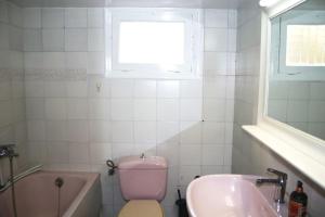 een badkamer met een roze toilet en een wastafel bij Amazing Centrally Located Apartment in Heraklion