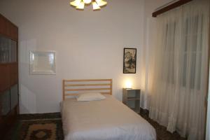 een slaapkamer met een bed in een witte kamer bij Amazing Centrally Located Apartment in Heraklion