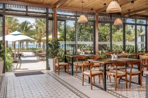 un ristorante con tavoli e sedie e vista sull'oceano di Andochine Villas Resort & Spa Phu Quoc - All Villas with Private Pool a Phu Quoc