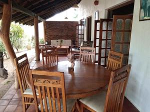 uma sala de jantar com uma mesa de madeira e cadeiras em Eagles Wing's GuestHouse em Habarana