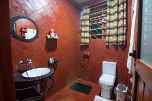 a bathroom with a toilet and a sink and a mirror at JET VILLAS ENTEBBE ( JVE ) in Entebbe