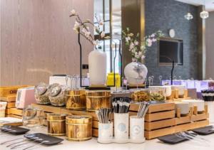 una mesa con platos, utensilios y jarrones en Premier City Comfort Hotel Quanzhou Wanda Plaza, en Donghai