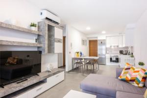 ein Wohnzimmer mit einem Sofa und einer Küche in der Unterkunft Luminoso Apartamento en La Tejita in Granadilla de Abona