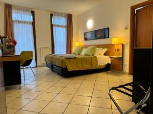 a hotel room with a bed and a desk and chairs at Residence Malpensa in Somma Lombardo