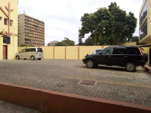 zwei Autos stehen auf einem Parkplatz. in der Unterkunft Pensao Martins in Maputo