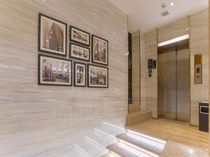 a lobby with pictures on the wall and a elevator at City Comfort Inn Wuzhou Sun Plaza Wanda in Wuzhou