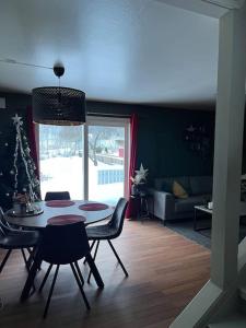 un soggiorno con tavolo, sedie e albero di Natale di Sentrumsnært hus a Rjukan