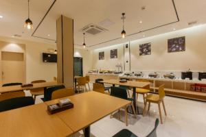 una caffetteria con tavoli e sedie e una cucina di City Comfort Inn Shaoguan Biguiyuan Phoenix City Gold Village a Shaoguan