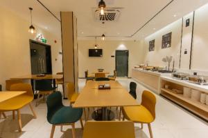 un ristorante con tavoli, sedie e bancone di City Comfort Inn Shaoguan Biguiyuan Phoenix City Gold Village a Shaoguan