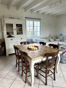 cocina con mesa, sillas y sofá en Maison de l'Anse, plage à 100m en Névez