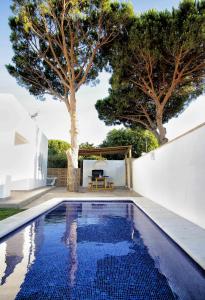 una piscina en el patio trasero de una casa con un árbol en Casas Palma Zahora Piscina Privada, en Zahora
