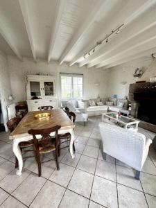 uma grande sala de estar com uma mesa e um sofá em Maison de l'Anse, plage à 100m em Névez