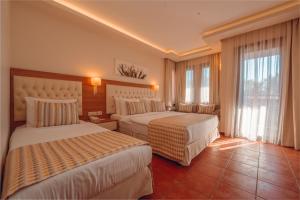 a hotel room with two beds and a window at Sundia By Liberty Suncity in Oludeniz