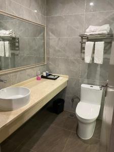 a bathroom with a sink and a toilet and a mirror at JTOUR Inn Maoming Huazhou Beijing Road Railway Station in Sanguantang