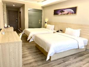 a hotel room with two beds at JTOUR Inn Maoming Huazhou Beijing Road Railway Station in Sanguantang
