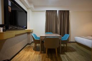 um quarto de hotel com uma mesa e cadeiras e uma cama em City Comfort Inn Huaihua East Station em Huaihua