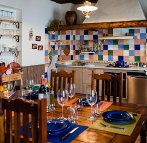 a kitchen with a wooden table with wine glasses at Hotel Rural El Cielo Entejado in Tejado