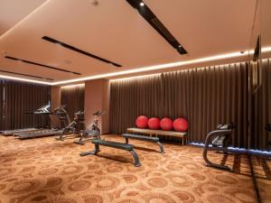 a gym with treadmills and exercise equipment in a room at Echarm Plus Hotel Foshan Wisdom New Town Metro Station in Shiwan